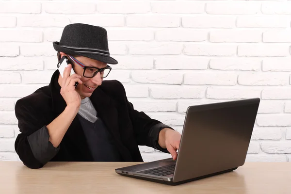 Lycklig man använder smartphone och laptop dator. — Stockfoto