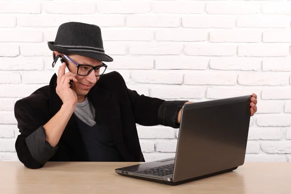 Lycklig man använder smartphone och laptop dator. — Stockfoto