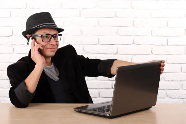 Lycklig man använder smartphone och laptop dator. — Stockfoto