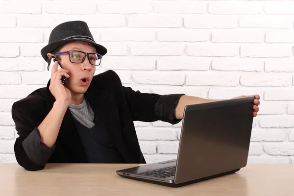 Glücklicher Mann mit Smartphone und Laptop. — Stockfoto