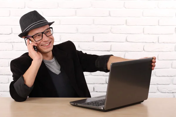 Lycklig man använder smartphone och laptop dator. — Stockfoto