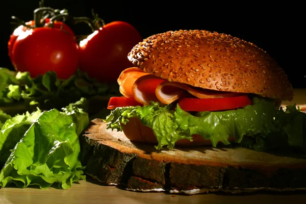 Sandwich a rajčaty na dřevěný stůl — Stock fotografie