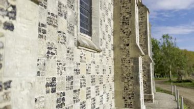 Saint-Valery-sur-Somme, Fransa 'daki Chapelle Saint Valery' nin kireçtaşı ve kireçtaşı damalı maskaralığı, gül penceresi, payandaları ve parlak mavi gökyüzü altında yıpranmış taş dokusu