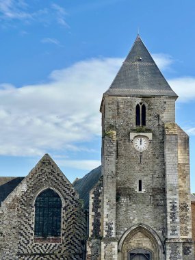 Saint-Valery-sur-Somme, Picardy, Fransa 'daki Saint-Martin Kilisesi, Orta Çağ çakmaktaşı ve kireç taşı Gotik portalı, uzun kare saat kulesi, kartonpiyer pencere ve yıpranmış taş detaylar.
