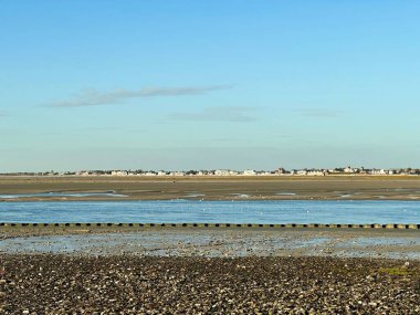 Le Crotoy Somme Körfezi 'nin karşısında, alçak sularda, gelgit düzlüklerine dağılmış sayısız siyah başlı martılar ve Cap Hornu yakınlarındaki mavi kanallar, engin açık gökyüzü ve yumuşak akşam ışığı kıyı manzarası biçiminde