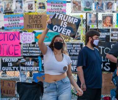 Washington DC, ABD 11 / 06 / 2020: Siyah Yaşamlar Önemlidir Plaza 'daki güzel sarışın bir kadın Beyaz Saray yakınlarındaki Joe Biden' ın zaferini kutlarken Trump 'ın bittiğini söyleyen bir bayrak sallıyor. 