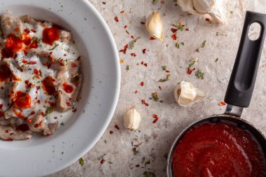 Geleneksel Türk mantisi, ezilmiş kırmızı biber ve kurutulmuş nane ile tatlandırılmış sarımsaklı yoğurt ve domates sosuyla servis edilen bir hamur tatlısı türüdür. Resim onu porselen tabakta gösteriyor..