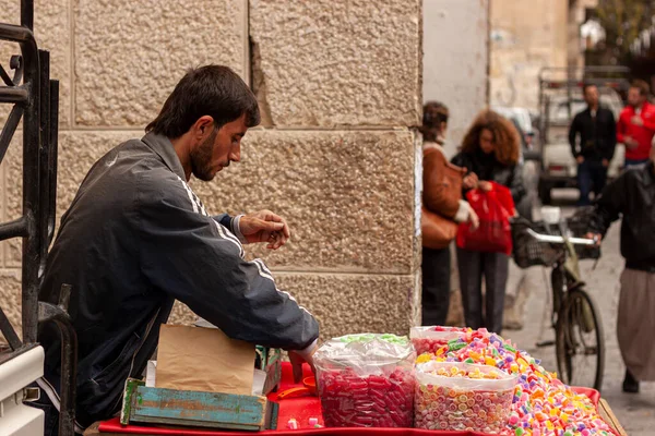 2010年3月3日至28日 叙利亚大马士革 一名年轻的阿拉伯男子在大马士革老城街头的购物车上卖糖果 在没有卫生措施的情况下陈列成堆的各种糖果 — 图库照片