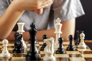 Beyaz bir çocuğun satranç oynarken eli alnında derin düşünceler içindedir. Endişeli bir duruşla aşağıya bakıyor. Pişmanlık, hata, kaybetme, umutsuzluk kavramları için çok yönlü görüntü