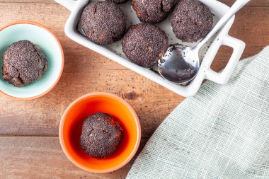 Tatlı kahverengi kek toplarının düz görüntüsü. Fırında pişirilmiş ve kütük ya da şurup içine batırılmış ve haşhaş tohumlarıyla kaplanmış. Bu tatlının adı Hashasli tatli (geleneksel Türk tarifi))