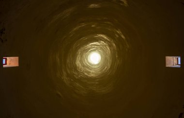 Eski bir binadaki uzun baca görüntüsü. Yukarıdaki delikten içeri ışık giriyor ve yan taraftaki iki pencere. İki farklı çıkışı olan eldivenli bir merkez. Mistik karamsar bir görüntü..