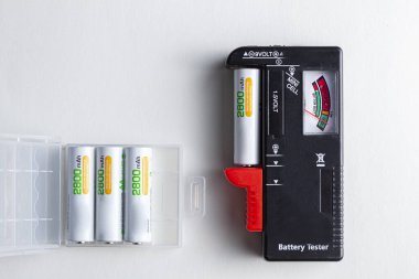 Kenarında klemp olan siyah bir plastik batarya testi. Böylece şarj seviyeleri ölçülebilir. Thel seviyesi bir iğne ile yan görüntülenir