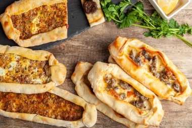 Kasarli sucuklu pide ve kiymali pide, et ve peynir soslu pizzaya benzer geleneksel Türk düz ekmekleridir. Limon ve maydanozla servis ediliyor. Tahtada pişmiş taze bir çeşit..