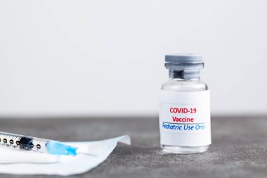 Pediatrik kullanım için tasarlanmış COVID 19 aşısını sadece iğne yapılmadan önce aşıyla dolu bir iğne ve şırıngayla gösteren konsept görüntü. Masaüstünde.
