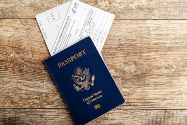 Clarksburg, MD, ABD 03-30-2021: Tahta arka planda ABD pasaportu, biniş kartı ve HHS COVID-19 aşı rekorunun üst görüntüsü yer aldı. Salgın konsepti sırasında seyahat düzenlemeleri.