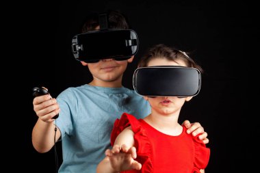 Beyaz bir erkek ve sanal gerçeklik kulaklığı takan bir kız çoklu oyuncu oyunu oynuyorlar. Çok oyunculu oyun sırasında çocukların farklı bir boyutta olduğu fütürist bir kavram. Bağımlılık etkinliği.