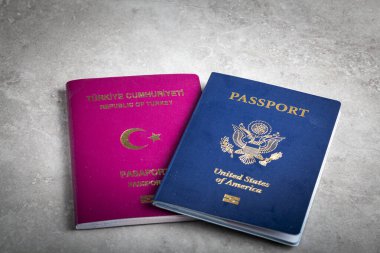 ABD pasaportu ve Türk pasaportu yan yana. ABD 'ye göç imajı, vatandaşlığa giden yol, çifte vatandaş, yurtdışında yaşamak ve ABD vatandaşı olmak için başvuru süreci.