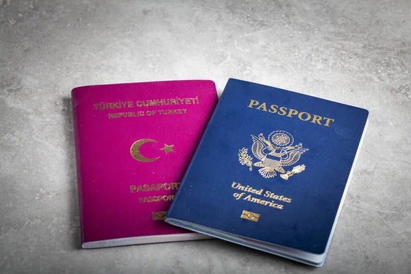 ABD pasaportu ve Türk pasaportu yan yana. ABD 'ye göç imajı, vatandaşlığa giden yol, çifte vatandaş, yurtdışında yaşamak ve ABD vatandaşı olmak için başvuru süreci.