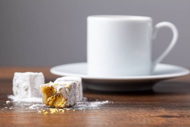 Geleneksel Türk kahvesi klasik fincanlarda Türk lezzetleriyle servis edilir. Arka planda metal bir kahve demliği var..