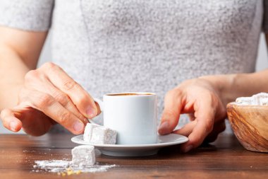 Kafkas Türk bir kadın özel fincandan geleneksel Türk kahvesi içiyor. Kahve tabağın yanında Türk lokumu ile servis edilir. Konsept resmini kapat.