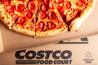 Clarksburg, MD, ABD 04-07-2021: Lezzetli taze kesilmiş pepperonili pizzanın izole edilmiş görüntüsünü kapatın ve karton kutuya koyun. COSTCO 'da indirimli olarak sunulan popüler bir gıda satış ürünüdür.