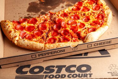 Clarksburg, MD, ABD 04-07-2021: Lezzetli taze kesilmiş pepperonili pizzanın izole edilmiş görüntüsünü kapatın ve karton kutuya koyun. COSTCO 'da indirimli olarak sunulan popüler bir gıda satış ürünüdür.