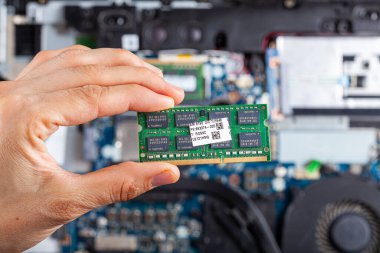 Arka planda açık bir dizüstü bilgisayar ile el ele tutuşan bir teknisyen ya da tüketicinin görüntüsünü kapat. Elektroniklerin geliştirilmesi ve onarımı için resmi kavra.