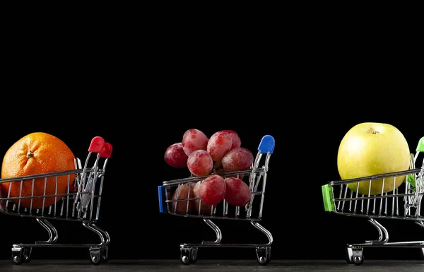 Imagen Fondo Oscuro Con Tres Carritos Compras Llenos Manzana Mandarina —  Fotos de Stock