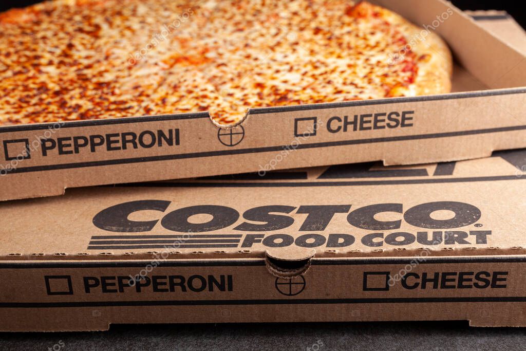 Clarksburg, MD, USA 04-7-2021: Closeup angled image of a carton box of delicious made to order COSTCO cheese pizza. Very popular bargain priced food court item from the wholesale giant.