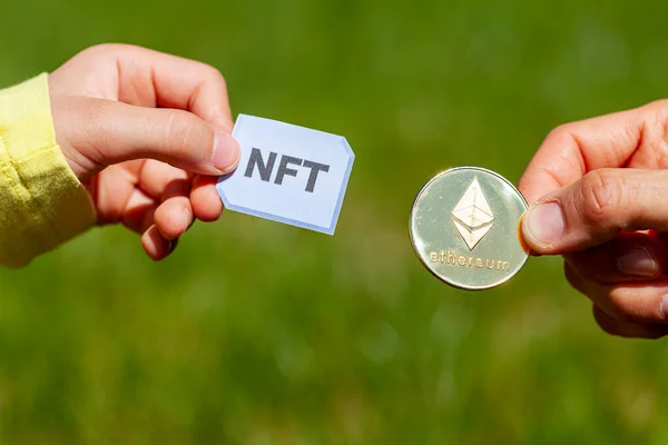 Ethereum engelleme zinciri aracılığıyla Fon Fonu Olmayan Jeton 'lara (NFT' lere) yatırım yapmak için bir konsept resim. Bunlar internette satılan nadir dijital eşyalar. NFT ve ETH paralarıyla bir aktarım görüntüle