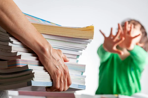 Ambitious parenting with high academic achievement expectations from kid concept. A mother is bringing a pile of test prep books to her bored tired kid who is saying no and protesting during homework.