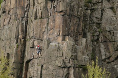bir kayanın üzerinde kadın dağcı