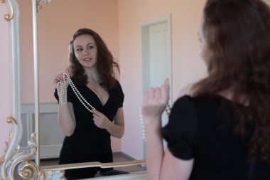 Ayna içinde poz boncuk çekici esmer genç kadınla