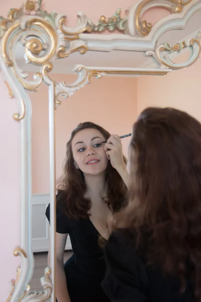Wanita muda berambut cokelat yang menarik dengan eye-liner di cermin — Stok Foto