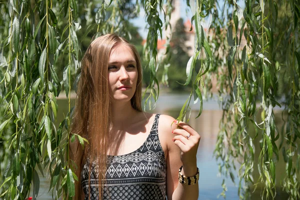 Fille posant avec des vignes de saule dans le jardin vert — Photo