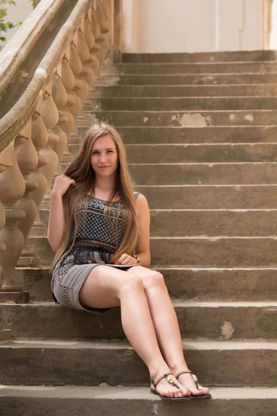 年轻的女人坐在一个旧的楼梯 — 图库照片