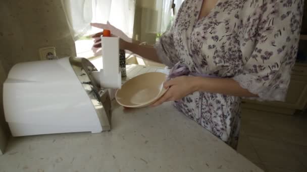 Flicka skär morötter i en mixer i köket — Stockvideo