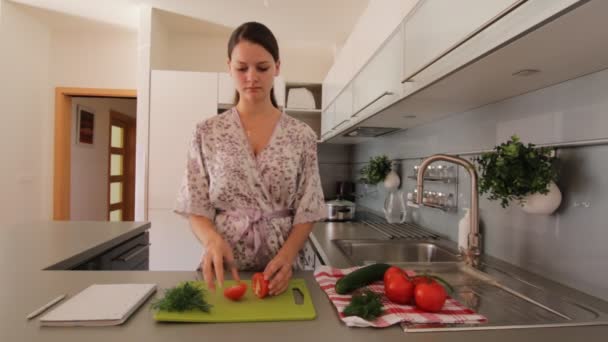 Женщина на кухне режет свежий овощ — стоковое видео