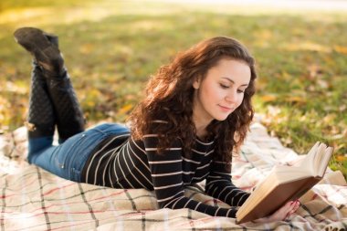 Sonbahar parkta kitapta olan kadın