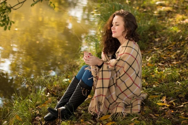 Jeune femme avec couverture dans le parc à l'automne — Photo