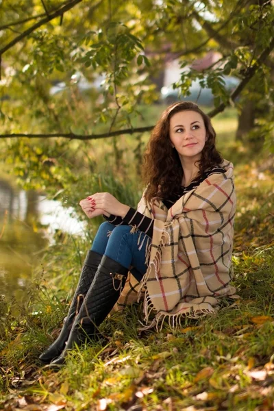 Młoda kobieta z kocem w parku jesienią — Zdjęcie stockowe