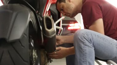 Ciddi genç adam onun motosiklet tamiri