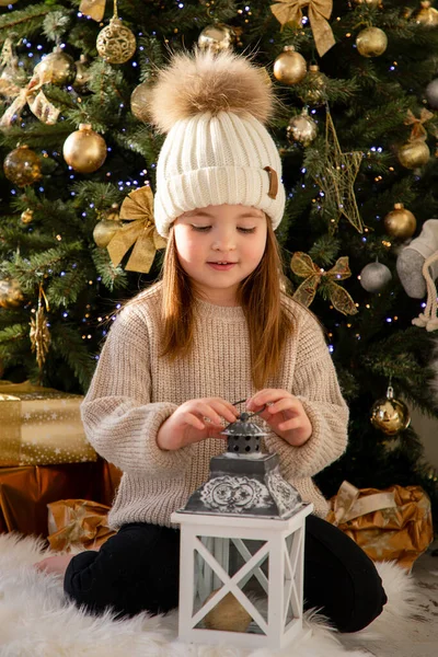 Cute little girl zabawy w pobliżu choinki wewnątrz. Wesołych Świąt i Szczęśliwego Nowego Roku — Zdjęcie stockowe
