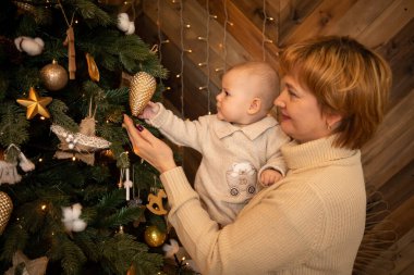 Güzel, mutlu bir anne ve örgü ören küçük kızı evde Noel ağacı süslüyorlar. Mutlu yıllar.