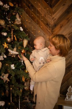 Güzel, mutlu bir anne ve örgü ören küçük kızı evde Noel ağacı süslüyorlar. Mutlu yıllar.