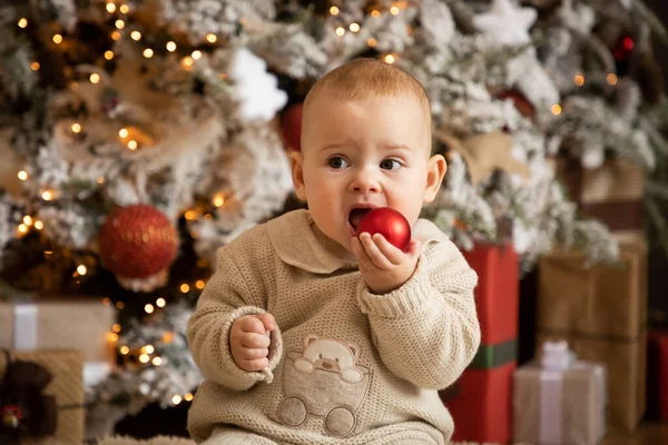 Cute baby girl siedzi z Christmas Ball w pobliżu choinek, Szczęśliwego Nowego Roku — Zdjęcie stockowe