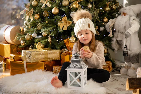 Cute little girl zabawy w pobliżu choinki wewnątrz. Wesołych Świąt i Szczęśliwego Nowego Roku — Zdjęcie stockowe