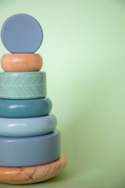 Yeşil arka plandaki çocuklar için güzel, ahşap bir oyuncak. Doğal ahşap malzemelerden yapılmış renkli piramit