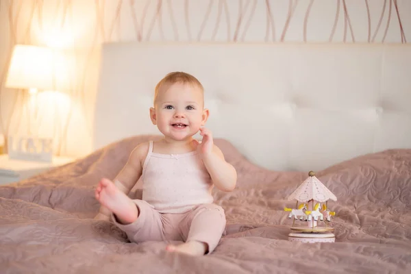 Linda niña jugando con juguetes de madera en el dormitorio de casa. Interior de vivero moderno en color rosa — Foto de Stock