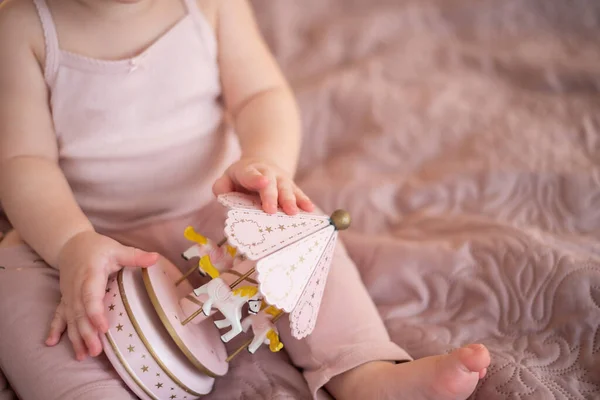 Linda niña jugando con juguetes de madera en el dormitorio de casa. Interior de vivero moderno en color rosa — Foto de Stock